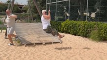 Granny attempts a zip-line ride and takes a comical fall straight into the sand below