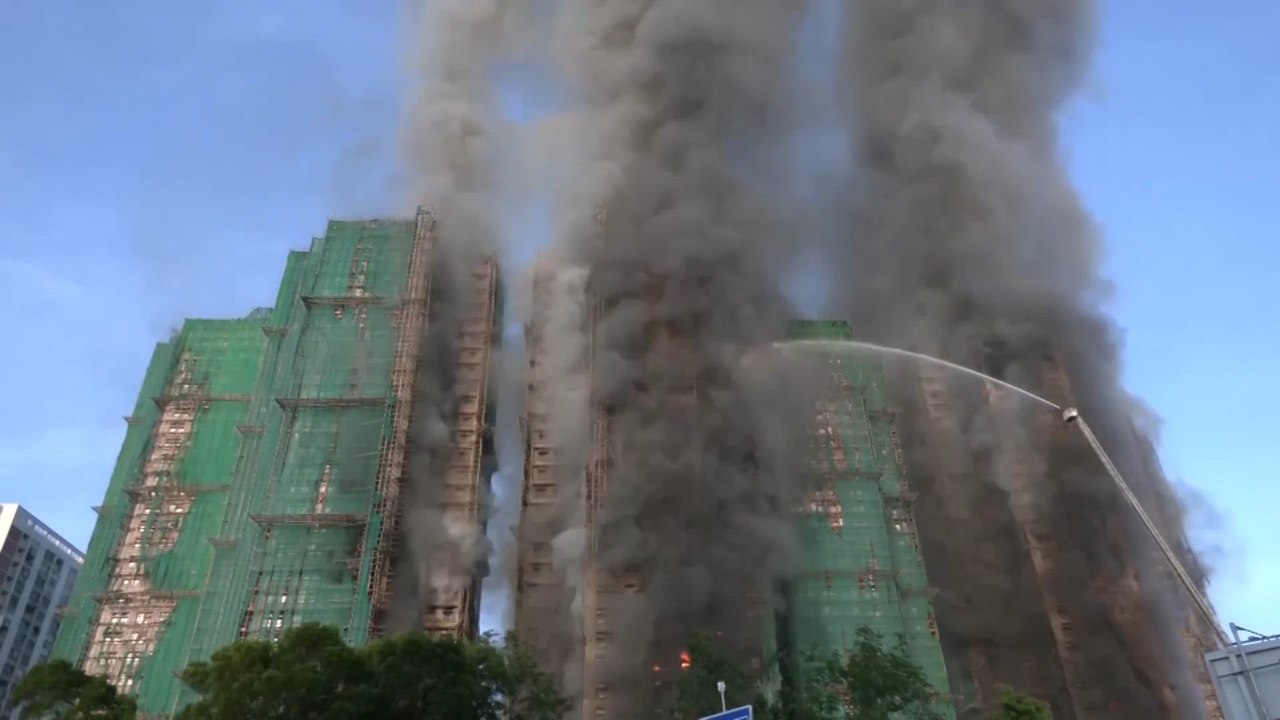 Los bomberos luchan durante toda la noche contra el enorme incendio en una torre de Hong Kong