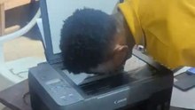 Young man uses a Canon printer to scan his own face in a lighthearted tech experiment