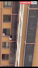 Çin’de infial yaratan görüntü: Binadan sarkıtılan kadın alt kata inmeyi başardı