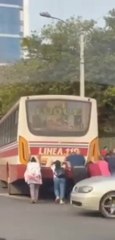 Pasajeros empujan un bus chatarra