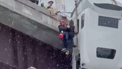 Driver stuck in truck dangling off icy bridge saved in dramatic rescue