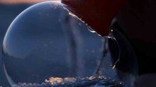 Pro soap bubble artist blows bubble that takes in the view of magical winter