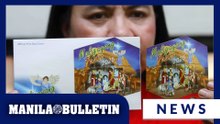 PHLPost employee displays newly issued 2025 Christmas stamps at Manila post office