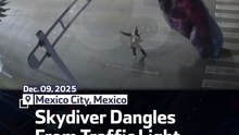 Skydiver Dangles From Traffic Light