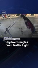 Skydiver Dangles From Traffic Light
