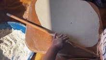 Woman Preparing Traditional Flatbread in Sunlit Kitchen