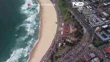 Centenas de pessoas juntam-se para depositar flores no local do tiroteio mortal na praia de Bondi