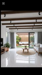 ✨ Check out this sleek modern oasis! ✨🔥‎‎🏡 *Living Room*: White glossy tiles, dark wood ceiling beams & track lights 💡, light gray sofa with wood legs, jute rug & wooden coffee table 🌱, big glass doors opening to the backyard vibes.