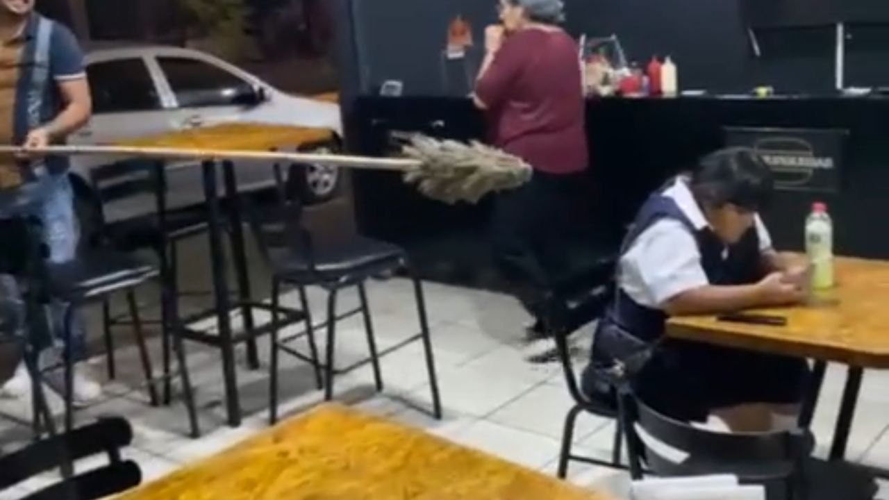 Little girl screams loudly when man extends a broom to scare her