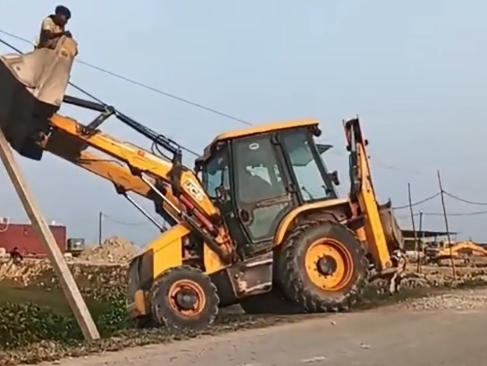 Bagger rammt Strommast und kippt in Feld