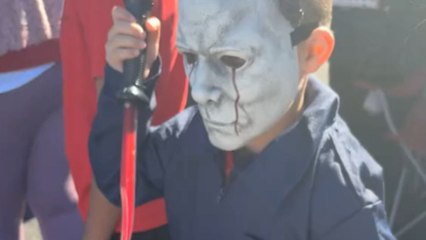 Two kids dressed as Michael Myers give each other death stares at Trunk or Treat