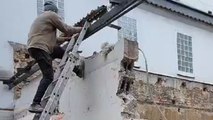 Demolition fail: Man conquers the wall but the door survives and stands tall