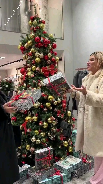 🛑Mükremin Gezgin ve Cemile Kaya, bir mağazadaki yılbaşı ağacı altında bulunan dekor kutularla hediyeleşti.
