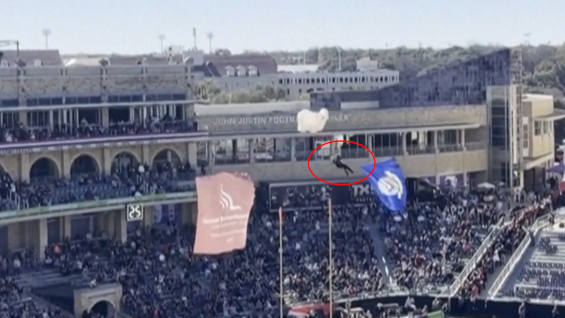 La ciudad de Fort Worth, en Texas, fue testigo el pasado viernes de un incidente que pudo haber terminado muy mal durante los proleg�menos de un partido de la Armed Forces Bowl. Lo que deb�a ser una entrada triunfal y coreografiada se transform� en un momento de m�xima tensi�n cuando un paracaidista perdi� el control de su vuelo en pleno descenso hacia el terreno de juego.
El espect�culo a�reo, habitual en los grandes eventos deportivos de Estados Unidos, se vio interrumpido cuando el especialista termin� por enredarse en la red de un estadio lleno de gente antes de que comenzara el encuentro. La maniobra fallida provoc� que el hombre perdiera la estabilidad necesaria para un aterrizaje seguro, precipitando su impacto contra la superficie.
El hombre cay� finalmente al suelo ante la sorpresa del p�blico en las gradas, que observaba con estupor c�mo el paracaidista se precipitaba tras quedar atrapado en la estructura de protecci�n del recinto.
A pesar de lo aparatoso de la escena y de la altura de la ca�da, el deportista no solo conserv� el conocimiento, sino que demostr� una entereza f�sica tras el impacto. El paracaidista se levant� sin problema tras su ca�da y, para tranquilidad de los asistentes, sali� del campo sin necesitar asistencia m�dica de urgencia.
La seguridad de los espectadores tambi�n fue una prioridad tras el incidente. Afortunadamente, tampoco se han registrado heridos o personas afectadas entre los aficionados presentes. Este hecho evit� que el error t�cnico se convirtiera en un accidente con m�ltiples v�ctimas en una jornada destinada a la celebraci�n deportiva.