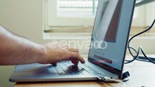 Hands Typing on Laptop Computer Keyboard at Desk