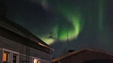 Northern lights illuminate the night sky in the city center with magical colors