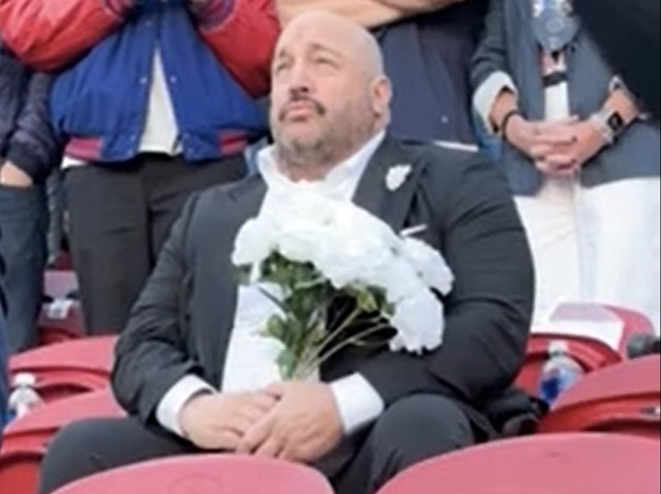 Kevin James traurig und alleine mit Blumenstrauß bei Super Bowl
