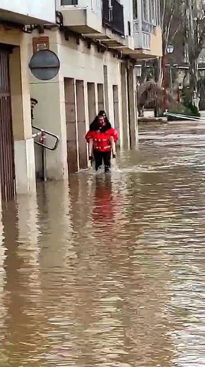 Los bomberos sacan a hombros a los vecinos de un portal inundado por el Duero en Aranda