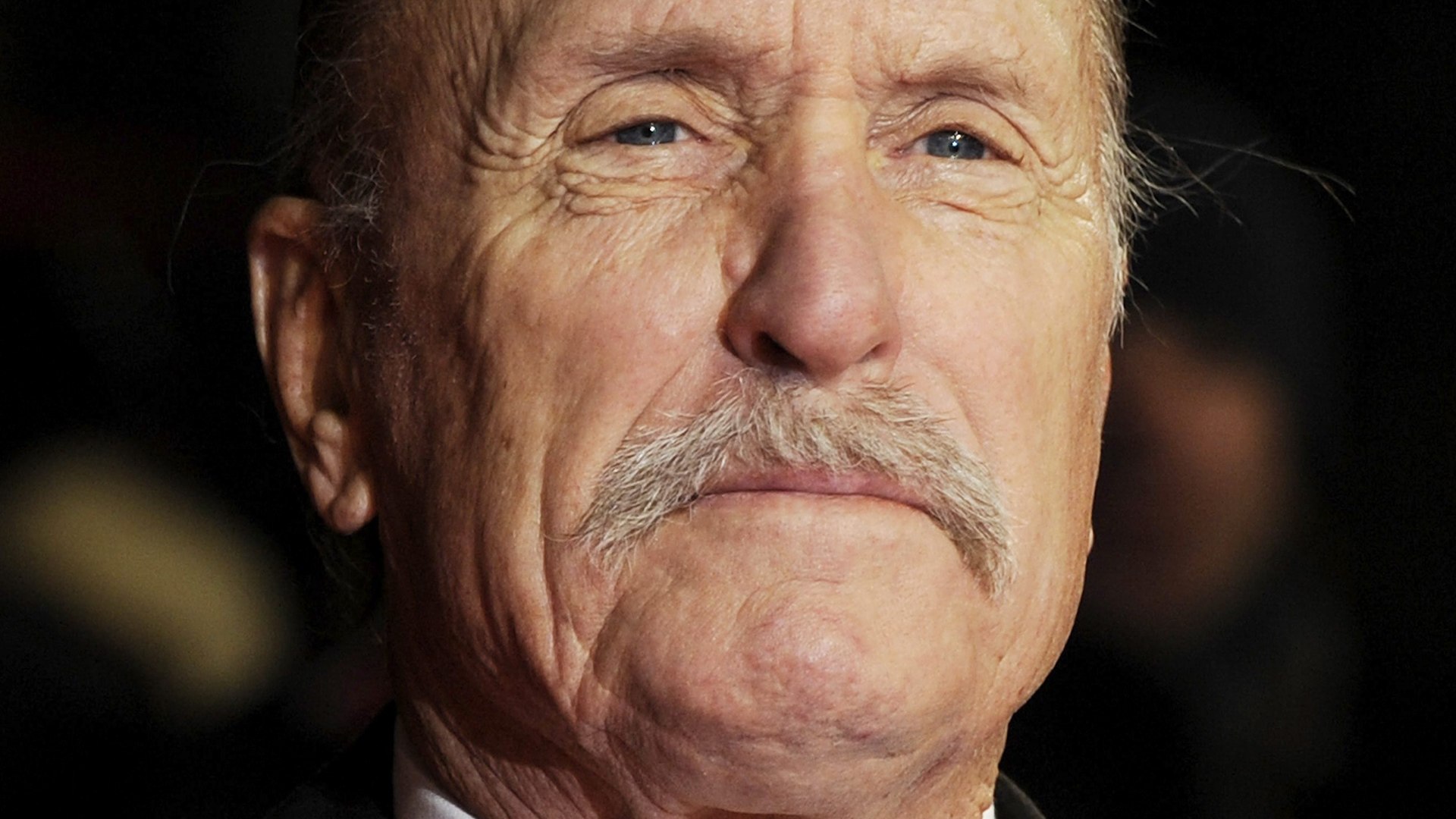 Hablar de Robert Duvall es evocar de inmediato una sucesi�n de t�tulos imprescindibles en la historia del cine. Su nombre remite a personajes inolvidables y a una carrera marcada por la versatilidad y la profundidad interpretativa. Fue el veterano polic�a al borde del retiro en Un d�a de furia, pero tambi�n el enigm�tico vecino recluido de Matar a un ruise�or. Sin embargo, su leyenda se ciment� especialmente con papeles como el de Tom Hagen en las dos primeras entregas de El Padrino y el del teniente coronel Kilgore en Apocalypse Now, donde dej� escenas ya inscritas en la memoria colectiva.
Integrante destacado de la generaci�n que transform� Hollywood en los a�os setenta, Duvall demostr� una asombrosa capacidad para la metamorfosis. Transit� con naturalidad por el drama, el thriller o el w�stern, siempre dotando a sus personajes de una humanidad compleja y cre�ble. Su talento parec�a inagotable y su presencia en pantalla, magn�tica. Este lunes, su esposa confirm� su fallecimiento a los 95 a�os en su rancho de Virginia, poniendo fin a una de las trayectorias m�s admiradas del cine estadounidense.