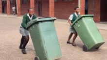 Girls race with bins until a collision sends one of them into a fall