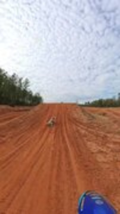 Poodle Takes Flight After Jumping Dirt Track Ramp Beside Dirtbike Rider