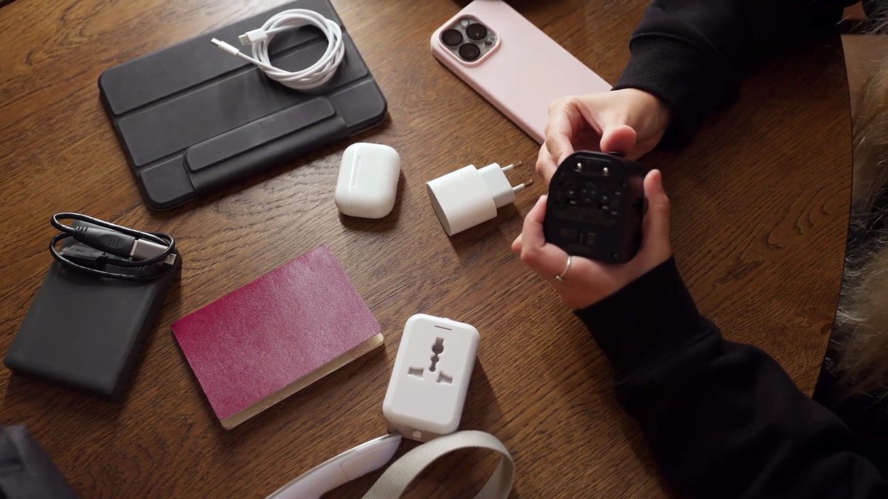 Woman Examining Multiple Socket Adapters at Table