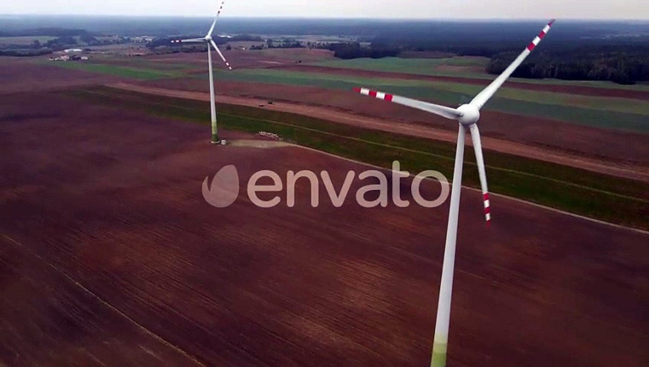 Windmill Wind Turbines Spinning Generating Renewable Electric Energy in Field