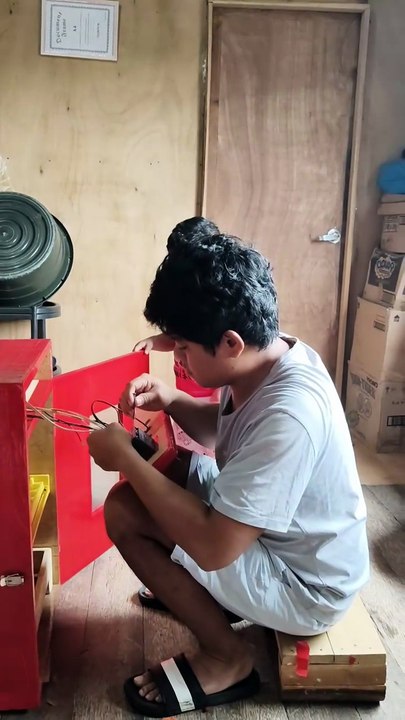 Isaiah looked at the egg incubator while his uncle Jeffrey was working on the egg incubator.