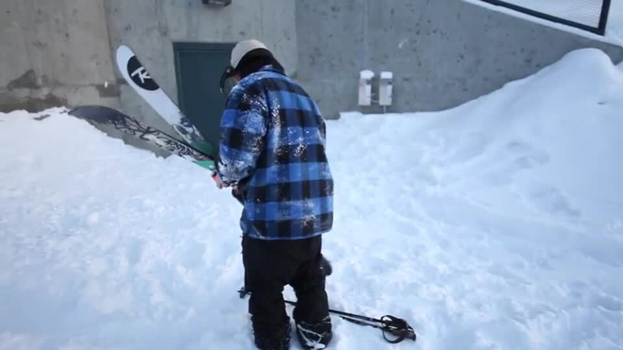 Person Carries Skis Across Snowy Field