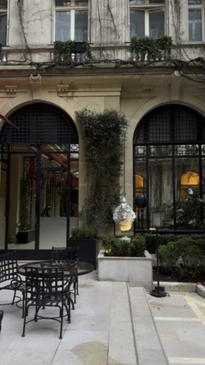Experience the quintessential Parisian elegance in the iconic red-carpeted courtyard of the Hôtel Plaza Athénée, where haute couture meets a lush, ivy-clad sanctuary.