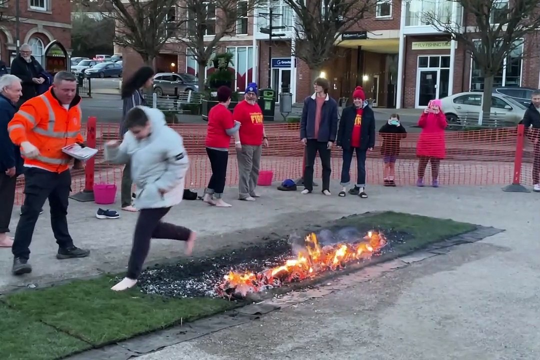 The youngest participant, 15, and Cath Kelly walking over the hot coals (Will Goddard, Crediton Courier)