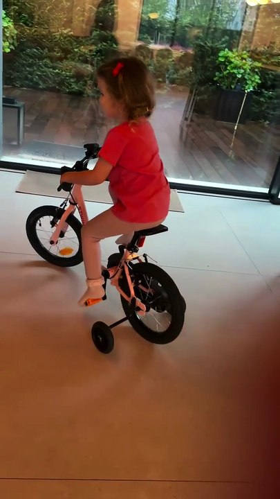 Vitaa filme sa fille Noa qui fait du vélo à deux roues.