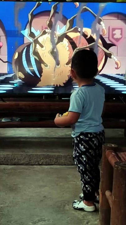 Isaiah watching TV and playing tiny car