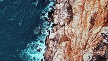 Breathtaking Top Aerial Slow Motion View of Azure Ocean and Waves Crashing at Rocky Cliff