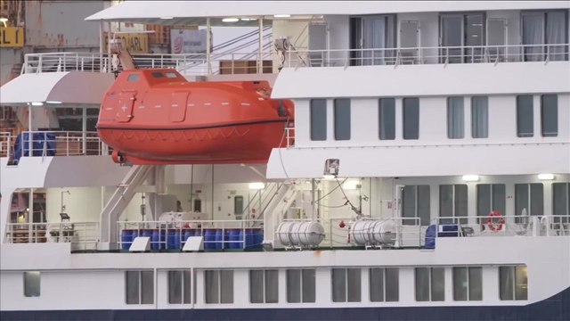 Passengers on MV Hondius wear masks as they await evacuation