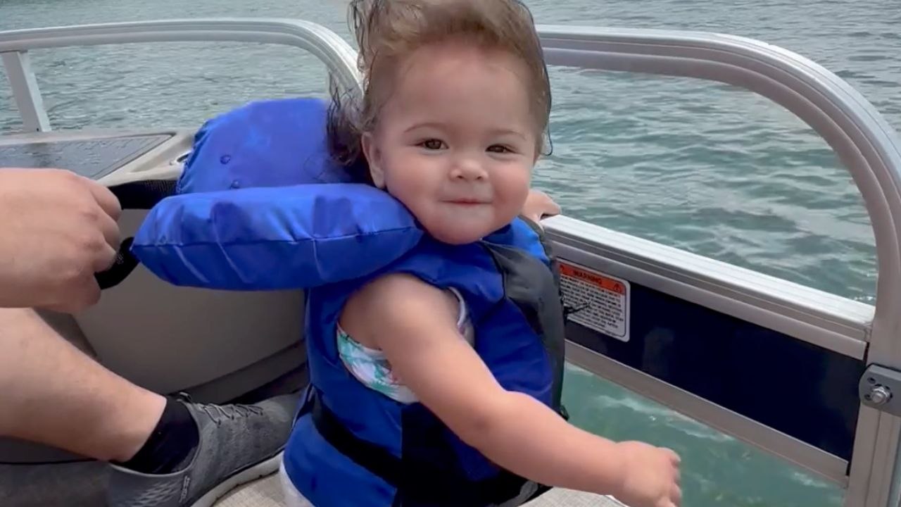 Little One Balances On A Moving Boat As Wind Whips Her Face
