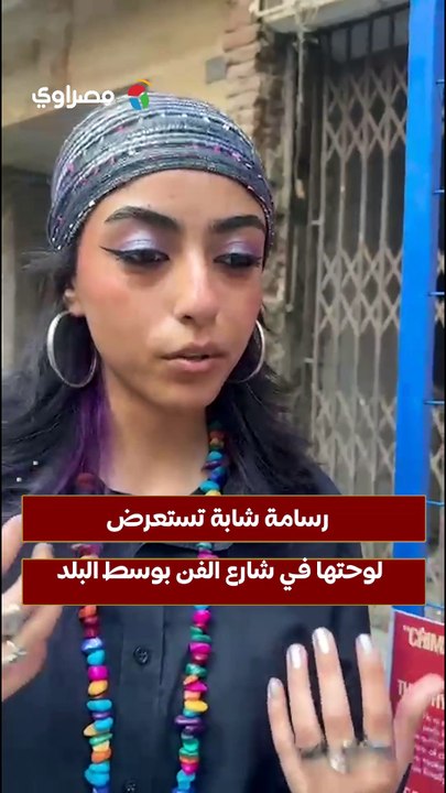 رسامة شابة تستعرض لوحتها في شارع الفن بوسط البلد