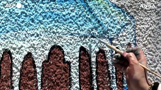 Gaza, artista palestinese dipinge sui muri danneggiati dalle bombe