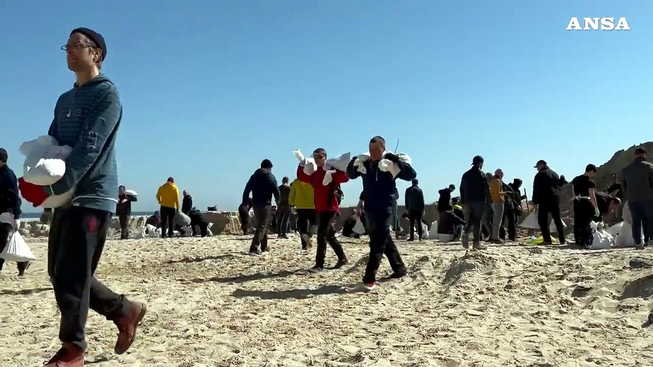Ucraina, volontari sulla spiaggia di Odessa riempiono sacchi di sabbia per le protezioni