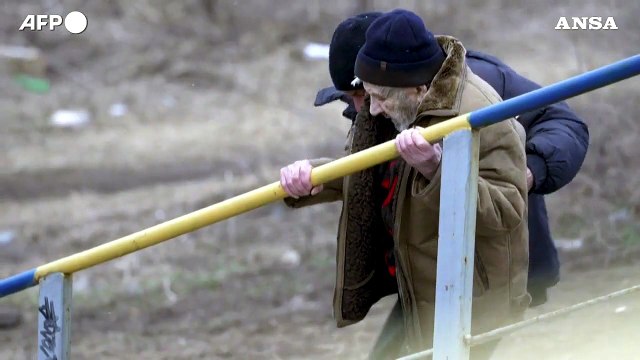 Ucraina, civili e soldati uccisi vengono evacuati attraverso un ponte bombardato