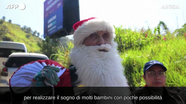 Guatemala, un pompiere vestito da Babbo Natale si cala da un ponte per regalare doni