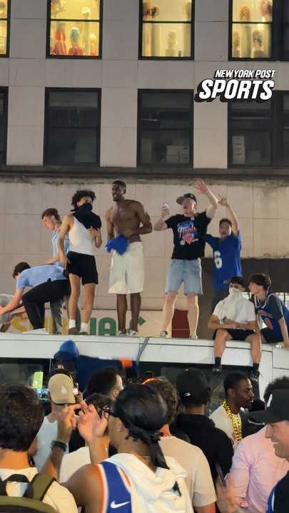 Knicks fans are celebrating on top of a police van