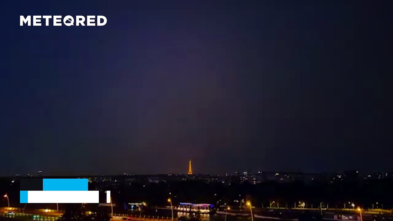 A massive nighttime storm lights up the sky over Paris, France
