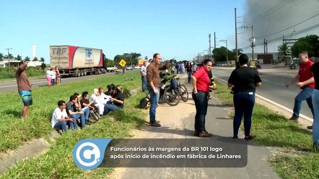 Funcionários às margens da BR 101 logo após início de incêndio em fábrica de Linhares