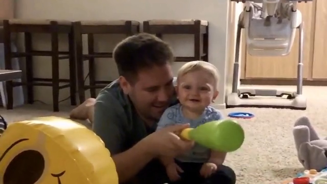 The boy shares endless giggles with dad and a smiley balloon
