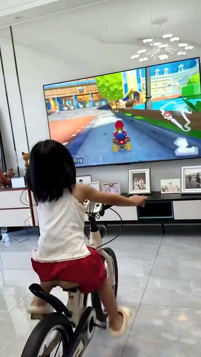 Une fillette transforme son vélo à roulettes en simulateur Mario Kart maison
