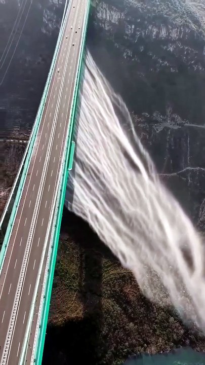 The Huajiang Canyon Bridge 花江峡谷大桥 in China creates its own waterfall