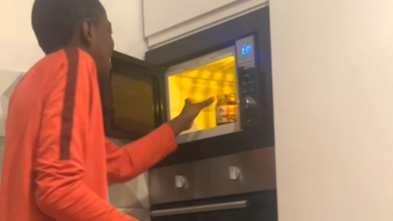 Sparks Flicker In A Microwave While A Boy Warms A Jar