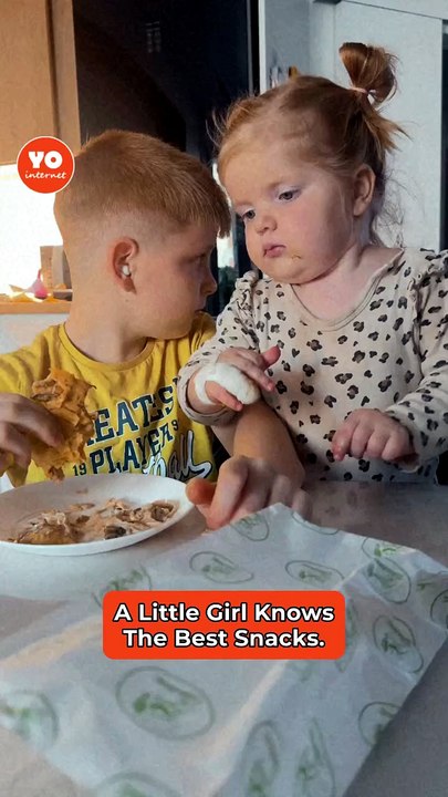 Young Girl Pilfers a Bite While Boy Grins and Looks Away